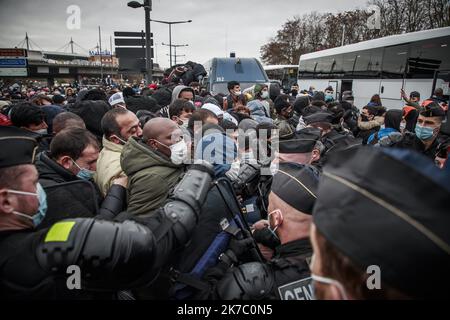 ©Christophe petit Tesson/MAXPPP - 17/11/2020 ; SAINT DENIS ; FRANCE - des gendarmes filent le passage de migrants avant leur transfert en bus vers un centre d'hébergement temporaire pendant l'évacuation de leur propre camp par la police. Plus de 2000 migrants vivaient entre le canal et le Stade de France sous l'autoroute. Les migrants attendent d'être évacués par les forces de police françaises dans un camp de migrants de fortune situé le long de l'autoroute A1 à Saint-Denis, au nord de Paris, en France, sur 17 novembre 2020. Banque D'Images