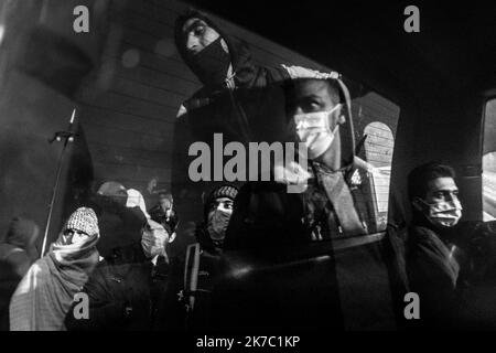 ©Michael Bunel / le Pictorium/MAXPPP - Michael Bunel / le Pictorium - 17/11/2020 - France / Ile-de-France / Saint-Denis - plusieurs groupes d'hommes se refletent dans le vitré d'une nuiture. Ils regardent les premières évacuations du camp. Évacuation du camp de refuges de Saint Denis. Entre 1500 et 2000 personnes vivant dans un camp insalubre depuis plusieurs mois. 17 novembre 2020. Saint Denis, France. / 17/11/2020 - France / Ile-de-France (région) / Saint-Denis - plusieurs groupes d'hommes se reflètent dans la fenêtre d'une voiture. Ils regardent les premières évacuations du camp. Évacuation du S Banque D'Images