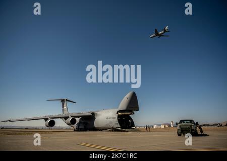 ÉTATS-UNIS Les aviateurs affectés à l'escadron d'intervention en cas d'urgence 921st effectuent un déchargement à partir d'un C-5M Super Galaxy alors que les moteurs fonctionnent tandis qu'un KC-10 Extender vole au-dessus pendant l'exercice Dragon Spark à la base aérienne de Travis, en Californie, le 14 octobre 2022. L'exercice Dragon Spark a offert aux unités de l'aile 60th de la mobilité aérienne et de l'aile 621st de l'intervention en cas d'urgence l'occasion de synchroniser les opérations en vue d'une catastrophe nationale. (É.-U. Photo de la Force aérienne par Nicholas Pilch) Banque D'Images