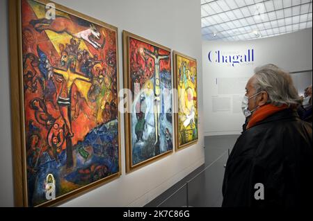 ©PHOTOPQR/L'EST REPUBLICAIN/ALEXANDRE MARCHI ; METZ ; 11/12/2020 ; CULTURE - EXPOSITION MARC CHAGALL PASSEUR DE LUMIERE - MUSÉE - PEINTURES - DESSINS - COLLAGES - VITRAUX. Centre Pompidou-Metz 11 décembre 2020. Une personne ayant un masque de protection regarde les trois tableaux 'résistance', 'Résurection' et 'libération' dans l'exposition inédite 'Chagall. Passeur de lumière' sur 1200 m² en galerie 3 du Centre Pompidou-Metz jusqu'au 26 avril 2021. PHOTO Alexandre MARCHI. - Metz, France, décembre 11th 2020 - exposition Marc Chagall. L'Emissary of Light au Centre Pompidou Metz Marc Chagall, Dé Banque D'Images