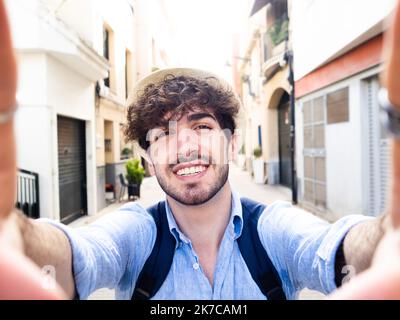 Un jeune touriste prend un portrait de selfie sur une rue de ville. Tourisme, été, réseaux sociaux Banque D'Images