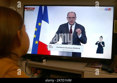 ©Pierre Teyssot/MAXPPP ; pandémie de coronavirus - le Premier ministre français Jean Castex s'adresse à Paris, France sur 18 mars 2021. Une fille regarde un écran de télévision montrant l'adresse du Premier ministre français Jean Castex. À Paris et dans le nord de la France, de nouvelles restrictions sur les voyages arriveront avec un verrouillage complet de 3rd pour essayer de ralentir la propagation des variantes du coronavirus. Â© Pierre Teyssot / Maxppp Banque D'Images