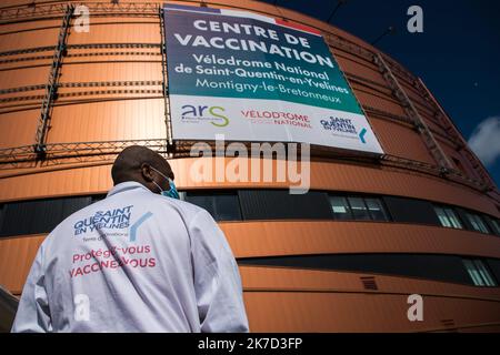 ©Christophe petit Tesson/MAXPPP - 26/03/2021 ; MONTIGNY LE BRETONNEUX ; FRANCE - un agent d'accueil devant le vélodrome de Saint Quentin transforme en centre de vaccination pour les personnes de + 55 ans ou attestation de comorbidites. Vue sur le centre de vaccination Covid-19 installé à l'intérieur du vélodrome national à Saint-Quentin-en-Yvelines, près de Paris. La France a annoncé le 23 mars qu'elle allait changer sa stratégie et pousser à une vaccination de masse en raison d'une augmentation des infections à coronavirus dans le nord de la France et dans la région de Paris. Banque D'Images