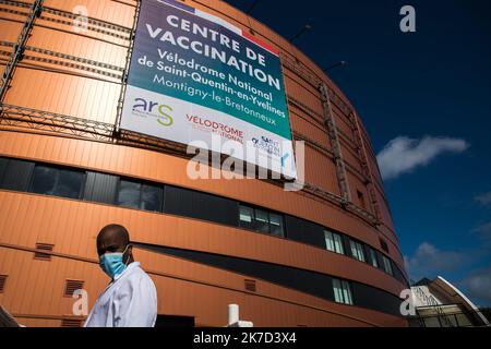 ©Christophe petit Tesson/MAXPPP - 26/03/2021 ; MONTIGNY LE BRETONNEUX ; FRANCE - un agent d'accueil devant le vélodrome de Saint Quentin transforme en centre de vaccination pour les personnes de + 55 ans ou attestation de comorbidites. Vue sur le centre de vaccination Covid-19 installé à l'intérieur du vélodrome national à Saint-Quentin-en-Yvelines, près de Paris. La France a annoncé le 23 mars qu'elle allait changer sa stratégie et pousser à une vaccination de masse en raison d'une augmentation des infections à coronavirus dans le nord de la France et dans la région de Paris. Banque D'Images