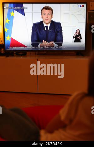 ©Pierre Teyssot/MAXPPP ; pandémie de coronavirus - allocution du Président français Emmanuel Macron à Paris, France sur 31 mars 2021. Une jeune fille regarde un écran de télévision montrant l'adresse du président français Emmanuel Macron. En France, un nouveau confinement en raison des différentes variantes du nouveau coronavirus sera en place pendant au moins 4 semaines en avril 2021. L'Europe essaie à nouveau de ralentir la propagation de la pandémie de Covid-19. Le président français Emmanuel Macron. Â© Pierre Teyssot / Maxppp Banque D'Images