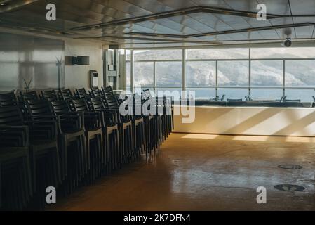 ©Pierre Berthuel / le Pictorium / MAXPPP - Pierre Berthuel / le Pictorium - 15/4/2021 - GRECE / Cyclades / Paros - le personnel de bord n'a pas juge nécessaire de préparer le ferry pour un grand nombre de passagers a bord du ferry Blue Stars en direction de l'ile de Paros, Tables et chaises sont encore des parcours. Sur l'ile de Paros dans les cyclades Grecs les professionnels du tourisme préparateur le progrès de la saison touristique. Le plan de vaccination s'accroiere sur l'ile et les mesures sanitaires se precisent. La tres touristique Ile de Paros est encore au calme avant l'arrivée de visites e Banque D'Images