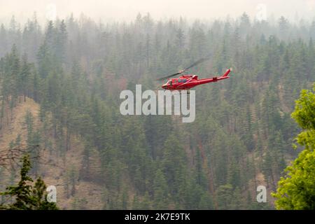 Un hélicoptère dépose de l'eau sur un feu de forêt qui brûle au feu du ruisseau Nohomin dans le parc provincial Stein Valley NlakaÕpamux Heritage, au nord de Lytton, Banque D'Images