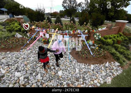 Raleigh, Caroline du Nord, États-Unis. 17th octobre 2022. AVIANNA LESTER, 9 ans, tient les mains de la grand-mère WENDY MITCHELL après avoir payé leur respect à un monument commémoratif croissant à l'entrée du quartier Hedingham. Un garçon de 15 ans était en détention alors que les enquêteurs cherchaient un motif dans une fusillade qui a tué un policier hors service et quatre autres à Raleigh, en Caroline du Nord (Image de crédit : © Bob Karp/ZUMA Press Wire) Banque D'Images