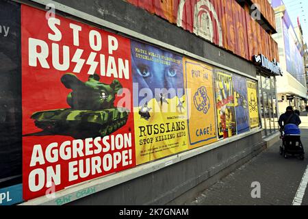 ©PHOTOPQR/L'EST REPUBLICAIN/ALEXANDRE MARCHI ; VARSOVIE ; 11/03/2022 ; GUERRE EN UKRAINE - CONFLIT - RUSSIE - POUTINE - POUTINE - AFFICHE - LA GUERRE EN EUROPE - SS. Varsovie 11 mars 2022. Une personne passe près d'affiches anti-Poutine colées sur un mur, de la rue Nowogrodzka, avec les inscriptions suivantes 'stop Russian (tank) agression on Europe !', 'Russians stop Killing gosses', 'put in cage !', 'Achtung sentarni Ukraina' et 'Achtung Russia (tank) en tête de Poutine. PHOTO Alexandre MARCHI. Varsovie (POLOGNE) 11 mars 2022. Une personne passe devant une affiche anti-Poutine sur un Banque D'Images