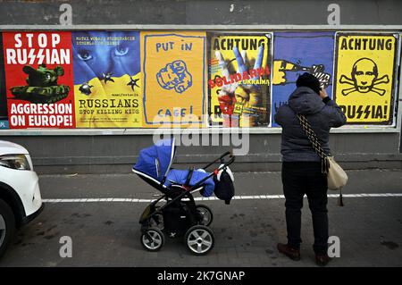 ©PHOTOPQR/L'EST REPUBLICAIN/ALEXANDRE MARCHI ; VARSOVIE ; 11/03/2022 ; GUERRE EN UKRAINE - CONFLIT - RUSSIE - POUTINE - POUTINE - AFFICHE - LA GUERRE EN EUROPE - SS. Varsovie 11 mars 2022. Une personne passe près d'affiches anti-Poutine colées sur un mur, de la rue Nowogrodzka, avec les inscriptions suivantes 'stop Russian (tank) agression on Europe !', 'Russians stop Killing gosses', 'put in cage !', 'Achtung sentarni Ukraina' et 'Achtung Russia (tank) en tête de Poutine. PHOTO Alexandre MARCHI. Varsovie (POLOGNE) 11 mars 2022. Une personne passe devant une affiche anti-Poutine sur un Banque D'Images