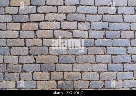 Vieux pavé de fond en granit. Vue de dessus sur la route en pierre de près. Banque D'Images
