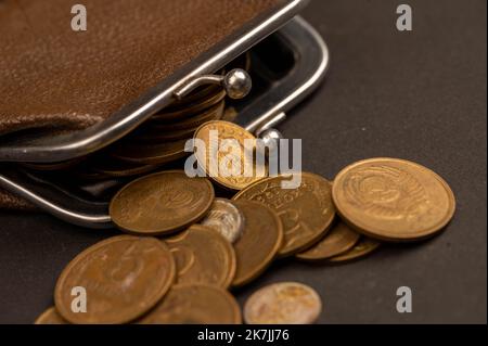 Anciennes pièces de monnaie de l'URSS et portefeuille vintage en cuir marron sur une surface en bois. Gros plan, mise au point sélective. Banque D'Images