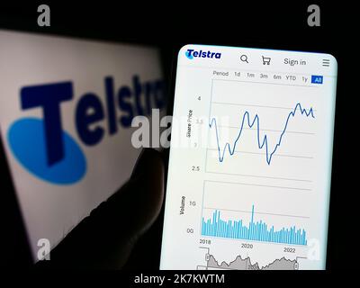 Personne tenant un téléphone portable avec la page Web de la société australienne Telstra Corporation Limited à l'écran avec le logo. Concentrez-vous sur le centre de l'écran du téléphone. Banque D'Images