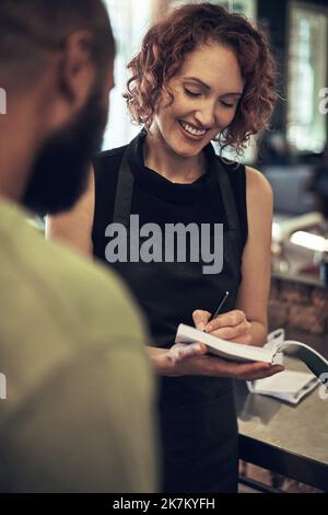 Mes clients ne partent jamais sans reçu. un jeune coiffeur debout et écrivant un reçu pour son client après avoir coiffé ses cheveux dans son salon. Banque D'Images