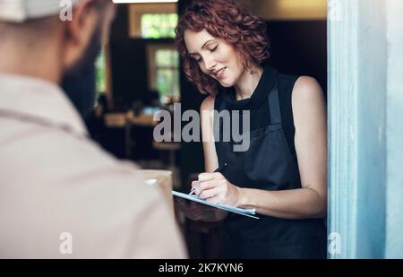 Est-ce que je signe ici. un jeune coiffeur attrayant signe pour une livraison du coursier à son salon. Banque D'Images