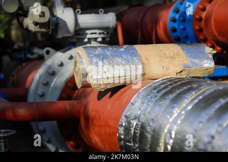 Détails de faible profondeur de champ (mise au point sélective) avec laine de verre industrielle utilisée pour isoler thermique un pipeline métallique d'eau chaude. Banque D'Images