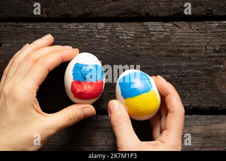 Deux oeufs de poulet, l'un avec le drapeau de la Russie est cassé et le second avec le drapeau de l'Ukraine est entier, la Russie a perdu la guerre, le pastica et la culture 2022 Banque D'Images