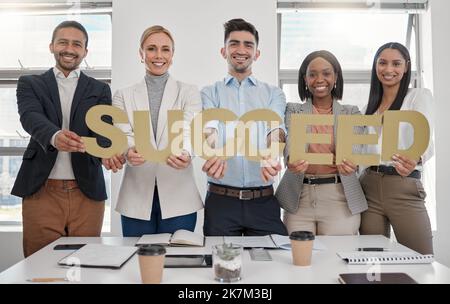 Travaillez dur pour les choses que vous voulez dans la vie. un groupe de jeunes travailleurs tenant un panneau dans un bureau. Banque D'Images