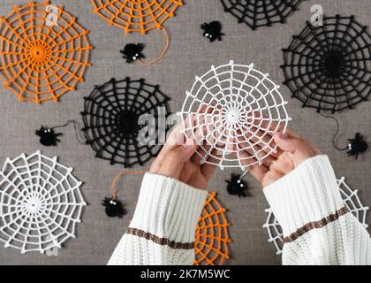 Un de beau coton blanc crocheted bandes latérales dans les mains de filles comme un petit cadeau d'Halloween fait à la main ou décoration d'automne maison. Vue de dessus. Banque D'Images
