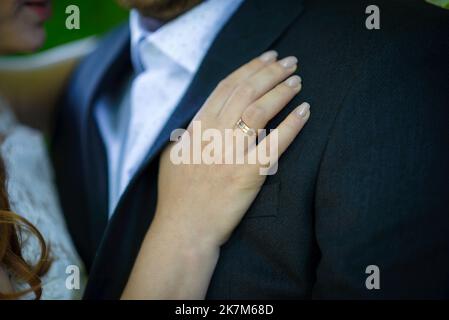 Photo de l'homme et de la femme avec l'anneau de mariage.Jeune couple marié tenant les mains, cérémonie de mariage jour. Les nouvelles mains de couple avec des anneaux de mariage. Banque D'Images