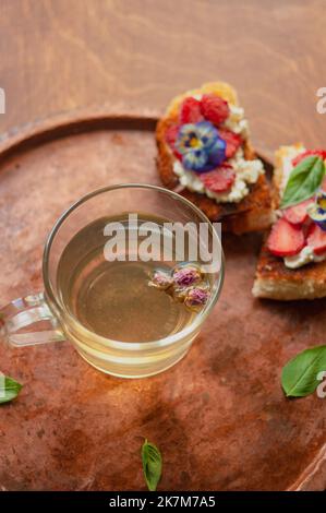 Pain doré aux fraises, brioche au fromage à la crème, fleurs et basilic plat Banque D'Images