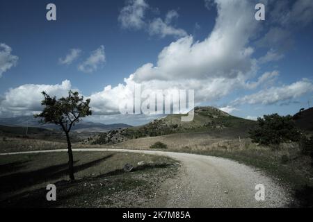 Paysage dans la lumière et l'ombre avec route de terre et arbre en Sicile, Italie Banque D'Images