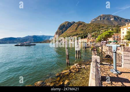 Vue panoramique depuis la promenade de Menaggio sur le lac de l'ouest du lac de Côme, Lombardie, Italie. Jour ensoleillé, un ferry approchant de la jetée. Banque D'Images