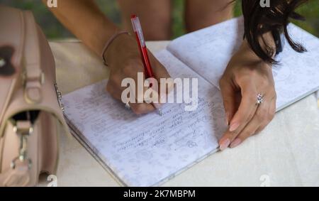 Gros plan main homme tiennent le stylo écriture sur papier blanc avec de l'espace pour le texte avec beaucoup de couleur de fond de stylo. Jour de mariage. Banque D'Images