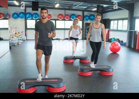 Groupe de personnes la flexion jambes sur les plates-formes étape Banque D'Images