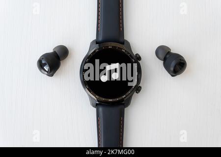 montre intelligente noire et casque sans fil sur fond blanc. Banque D'Images