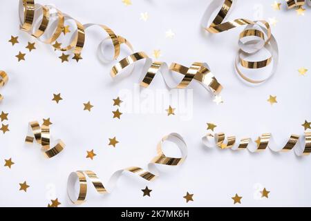 composition plate de rubans dorés ou de confetti en serpentin et doré sous forme d'étoiles sur fond blanc. Le concept d'anniversaire, anniversaire Banque D'Images