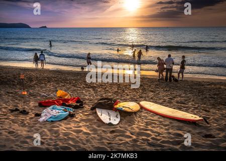 Vacanciers profitant d'un coucher de soleil spectaculaire sur la baie de Fistral à Newquay en Cornouailles au Royaume-Uni en Europe. Banque D'Images