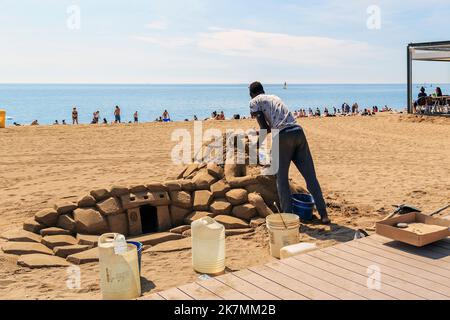 BARCELONE, ESPAGNE - 17 MAI 2017 : cet artiste de rue non identifié construit une figure de sable sur la plage de Barceloneta. Banque D'Images