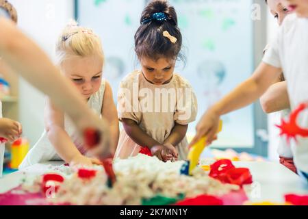 preschoolers faisant des figures avec le sable cinétique ardemment, moyen coup pépinière créativité concept de jeu. Photo de haute qualité Banque D'Images