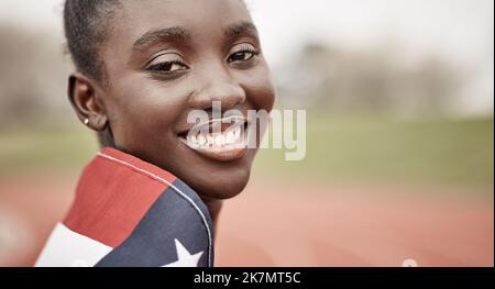 Être un athlète demande du dévouement. une belle jeune athlète féminine avec le drapeau américain enveloppé autour d'elle. Banque D'Images