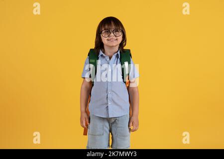 Concept Smart Kids. Un petit garçon mignon et un petit garçon qui porte des lunettes avec un sac à dos souriant, espace libre Banque D'Images
