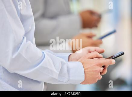 Doubler la mise sur les talents permet de faire avancer les choses. des hommes d'affaires méconnaissables utilisant des appareils mobiles dans un bureau. Banque D'Images