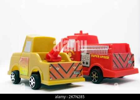 Camion de pompiers et remorqueur jouets isolés sur fond blanc avec des modèles en plastique de véhicules d'urgence et utilitaires Banque D'Images