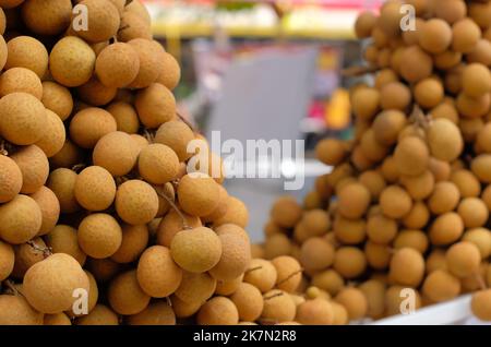 Fruits de longan frais sur le marché. Gros plan des fruits de longan ou de kelengkeng. Banque D'Images