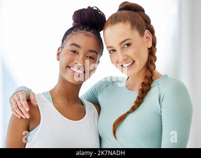 Nous lier par le yoga. deux jeunes femmes se tenant à proximité après avoir pratiqué le yoga. Banque D'Images
