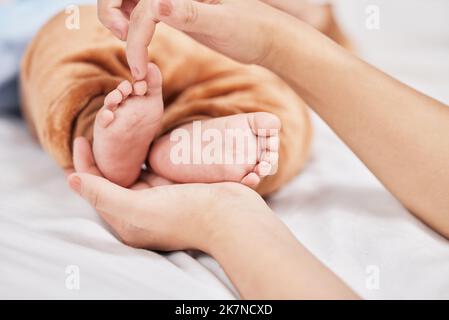 Dix petits orteils parfaits. une jeune mère tenant ses fils pieds pendant qu'il dort. Banque D'Images