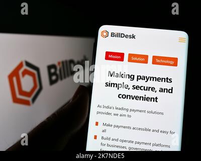 Personne tenant un téléphone portable avec la page Web de la société IndiaIdeas.com Limited (BillDesk) à l'écran devant le logo. Concentrez-vous sur le centre de l'écran du téléphone. Banque D'Images