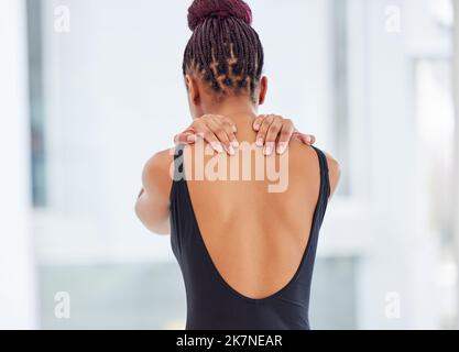 La douleur est dans mes épaules. une jeune ballerine souffrant de douleurs à l'épaule. Banque D'Images
