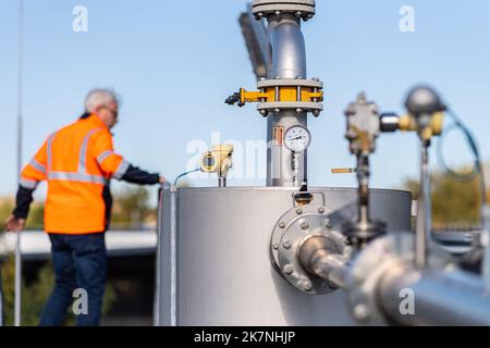 Coesfeld, Allemagne. 18th octobre 2022. Chez reTerra West GmbH, un employé se trouve sur le toit d'une usine de biogaz qui produit du biogaz à partir de déchets organiques. Wirtschaftsbetriebe des Kreises Coesfeld, en collaboration avec reTerra West GmbH, démontre comment le biogaz est traité à partir des matières premières et alimenté dans le réseau de gaz. 350 mètres cubes peuvent être produits ici par heure, ou 1500-2000 ménages peuvent être fournis avec du gaz naturel bio. Credit: Guido Kirchner/dpa/Alay Live News Banque D'Images