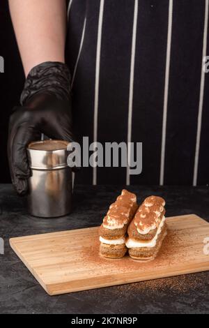 Faire un gâteau tiramisu dessert sur fond sombre dans un café Banque D'Images