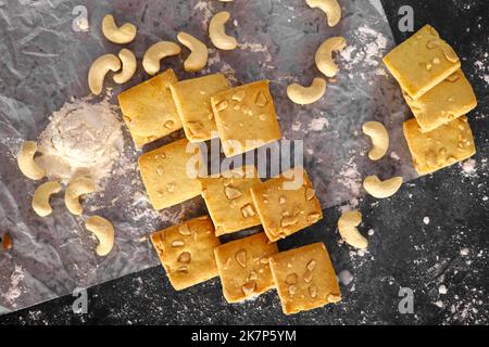 Petits gâteaux faits maison fraîchement cuits sur la grille du four sur fond sombre plat Banque D'Images