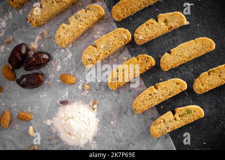 Petits gâteaux faits maison fraîchement cuits sur la grille du four sur fond sombre plat Banque D'Images