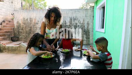 Les enfants hispaniques mangent le déjeuner, les enfants sud-américains brésiliens mangent le repas Banque D'Images