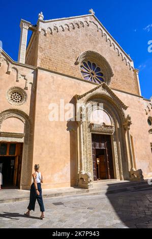 Une jeune italienne élégante se promène devant la basilique Sainte-Catherine d'Alexandrie, Galatina, Pouilles, Italie. Banque D'Images