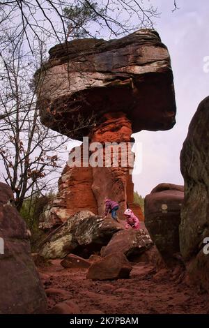 Hinterweidenthal, Allemagne - 1 janvier 2021: Deux enfants grimpant sur des rochers rouges sous la formation de roche appelée Table du diable dans la forêt du Palatinat Banque D'Images